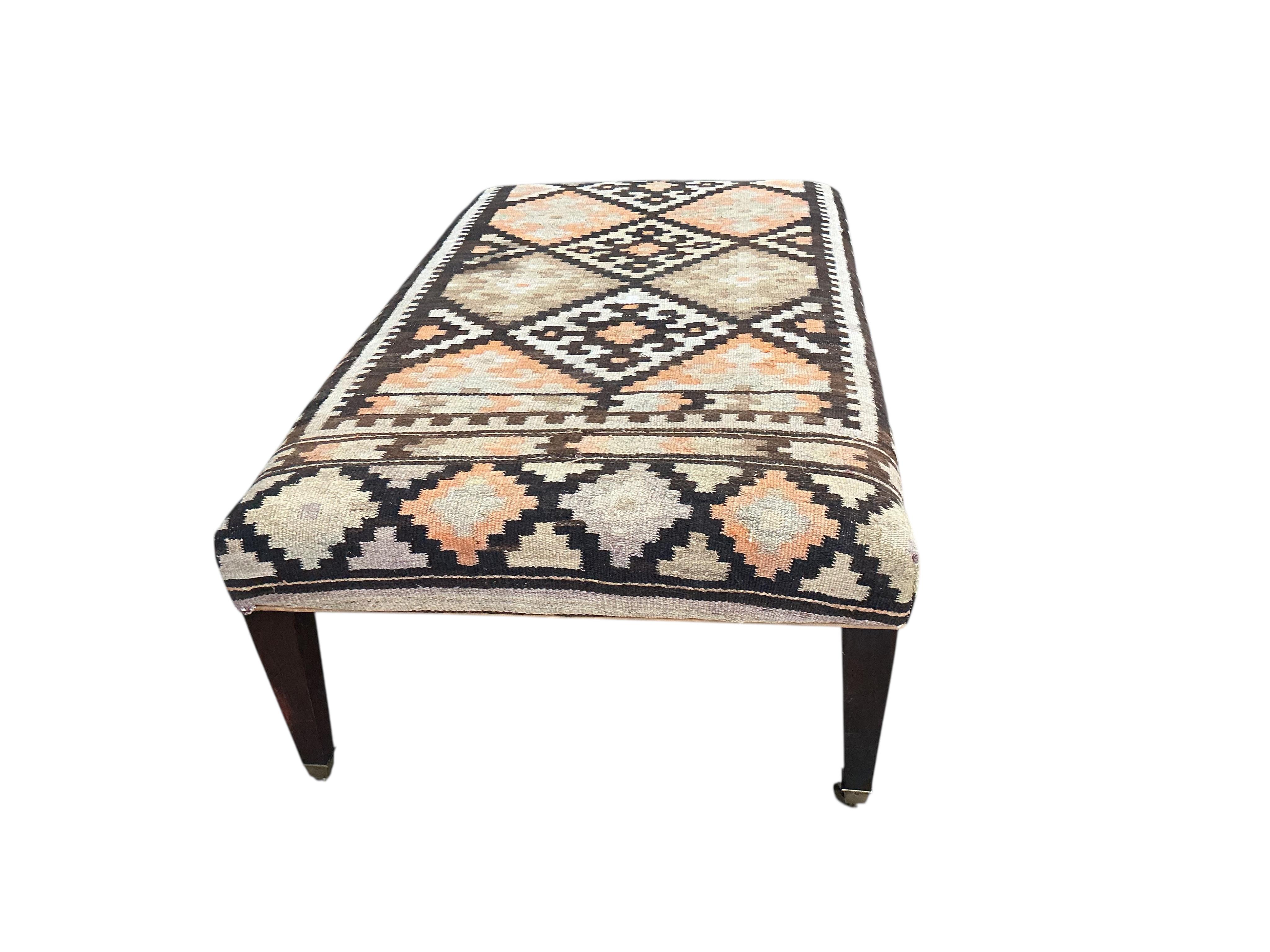 A large rectangular coffee table / footstool with polychrome Kilim upholstered top, width 143cm, depth 84cm, height 48cm